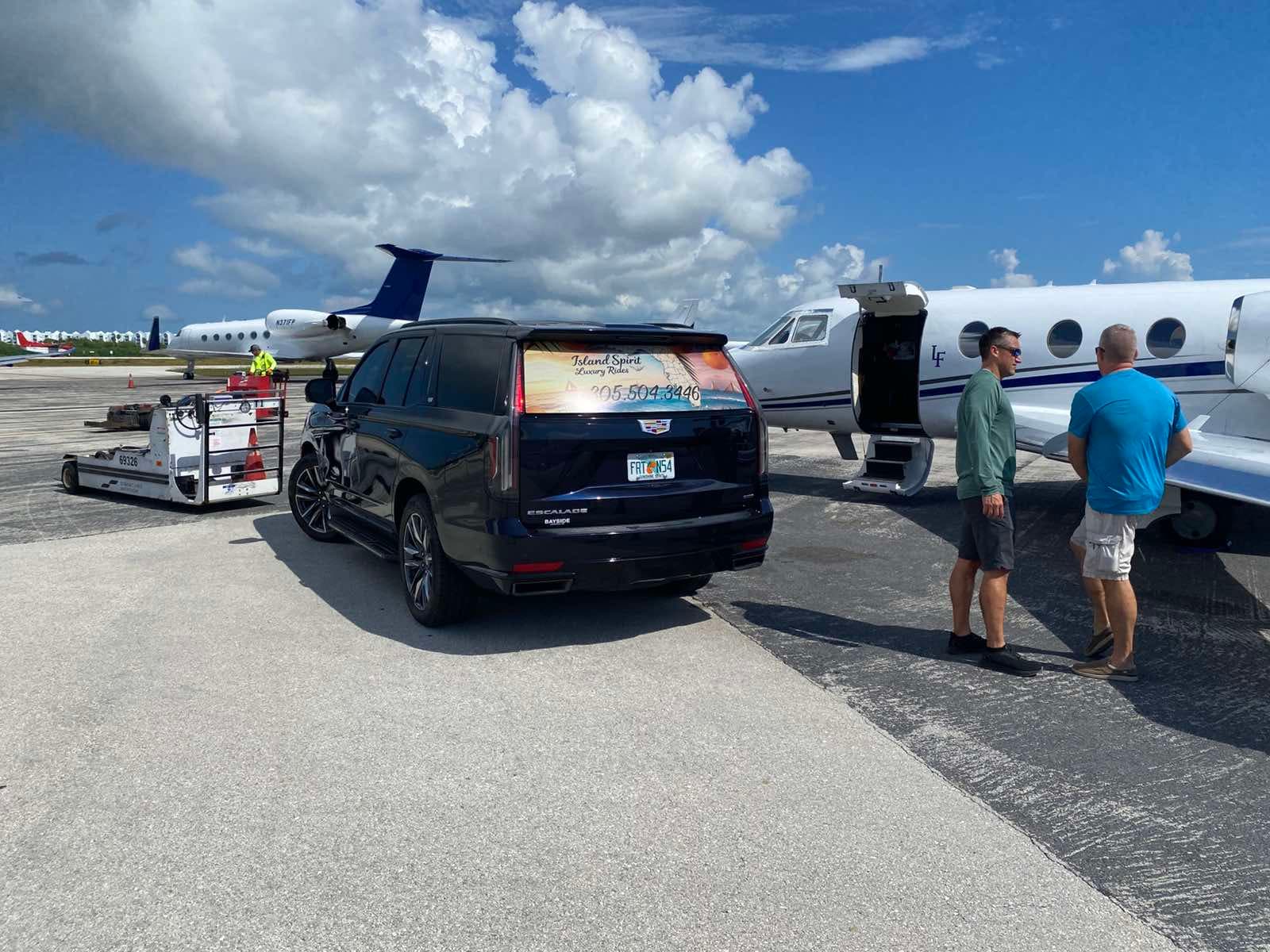Island Spirit Cadillac Escalade beside a private aircraft in Key West